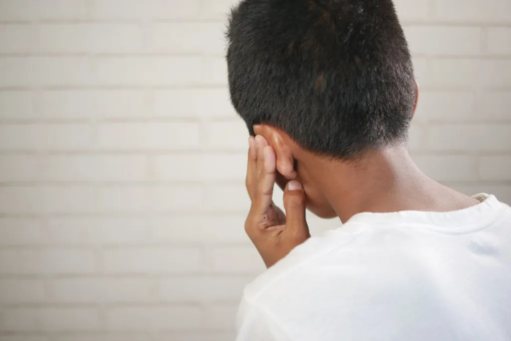 A child is depicted covering their ear, suggesting discomfort or concern.